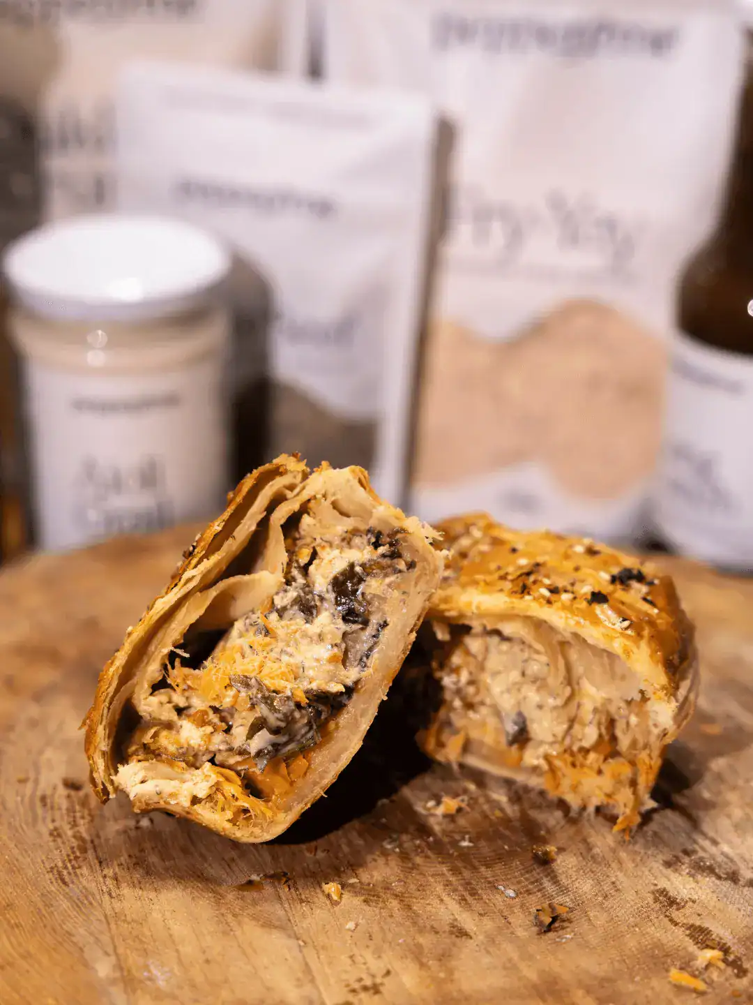 "The Gill-ty Pleasure" November Salmon Promo Pie cut open sitting on a wooden board. Pepper and Me products are in the background.